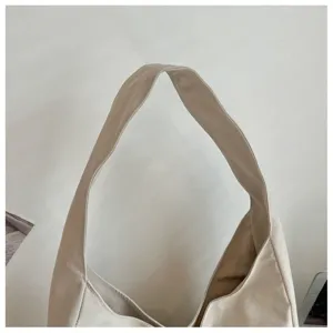 Nahaufnahme Detail des beigen Canvas Schultertaschenriemens im minimalistischen Stil.