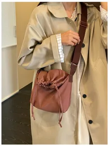 Vue détaillée du sac bandoulière élégant à cordon avec une sangle réglable et unie.