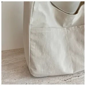 Detail der minimalistischen beigen Segeltuchtasche, stilvolle Alltagstote mit Vordertasche.