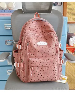 Detailopname van de roze corduroy schoolrugzak met schattige sterrenmotieven en zakken.