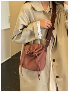 Vue de détail en gros plan d'un sac bandoulière décontracté uni avec sangle marron.