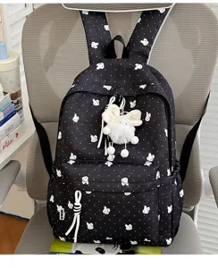 Gedetailleerd uitzicht op de zwarte rugzak met schattig wit konijnenpatroon en pluche hanger.