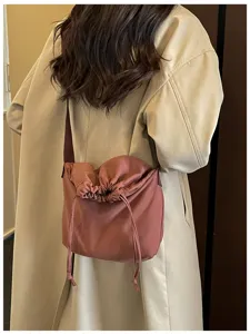 Vue détaillée du sac bandoulière élégant à cordon de serrage porté, style décontracté.