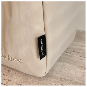 Minimalistische einfarbige Canvas Tragetasche Detailaufnahme mit feinem Stoff und Stickerei.