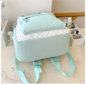 Gedetailleerd overzicht van de schattige lichtgroene en witte polkadot rugzak voor studenten.