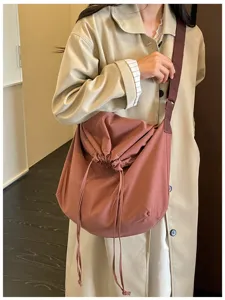 Gros plan détaillé sur le sac bandoulière minimaliste élégant à cordon de couleur unie.