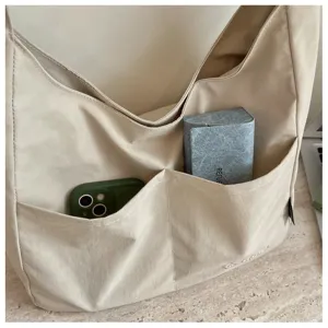 Detailansicht einer lässigen beige Segeltuch Schultertasche mit Vordertaschen für den Alltag.
