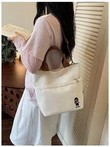 Vue détaillée du sac cabas en toile de style coréen avec poignées et poche avant.