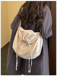 Vue détaillée d'un sac bandoulière minimaliste uni à cordon de serrage au quotidien.
