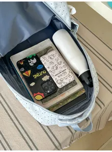 Gedetailleerd overzicht van een lichtblauwe rugzak met stippen en grote binnenruimte.