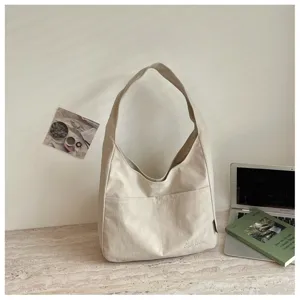 Detailansicht der lässigen Canvas-Umhängetasche mit Vordertasche im gemütlichen Zimmer.