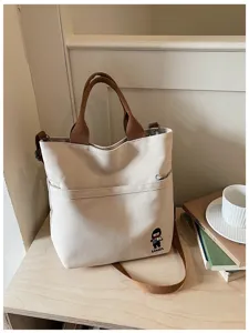 Sac cabas en toile détail, tissu épais, anses marron, sac bandoulière quotidien étudiant.