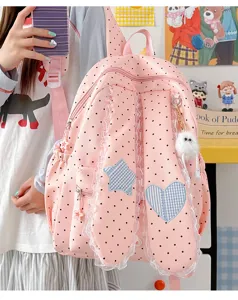 Detailed shot of cute pink polka dot bunny ear backpack with lace trim and star patch.