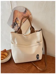 Gros plan détaillé du sac bandoulière en toile épaisse style coréen avec poche zippée et poignées.
