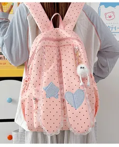 Pink polka dot backpack with lace bunny ears, star and heart patches for student daily use.