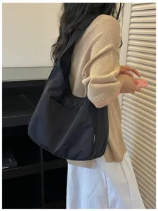Nahaufnahme einer minimalistischen schwarzen Canvas-Umhängetasche, lässiger Stil mit Stickerei.