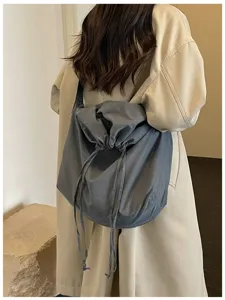 Vue détaillée du grand sac à bandoulière souple et ample avec cordon gris-bleu uni.
