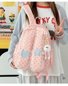 Detailed shot of cute pink polka dot backpack with bunny ears, lace trim and plush keychain.