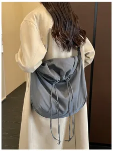 Vue détaillée du sac porté épaule gris décontracté à cordon avec un design souple.