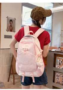 Détail de sac à dos rose à motif d'étoiles montrant un design mignon et des compartiments.