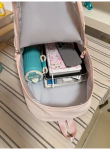 Gedetailleerd overzicht van de roze rugzak met grote binnencapaciteit en georganiseerde items.