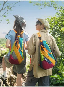 Outdoor scene detail of colorful patchwork sling backpack for hiking and travel, casual style.