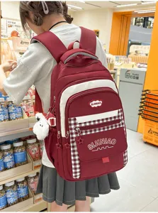 Detail van Koreaanse stijl schoolrugzak met rood-wit ruitpatroon en meerdere handige vakken.