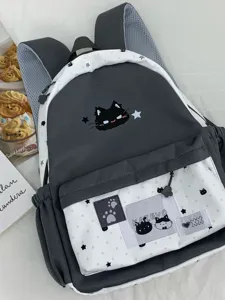 Detailopname van schattige grijze en witte rugzak met lief katten- en sterrenontwerp.