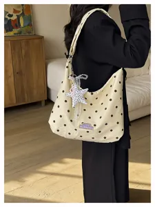 Detail van gestippelde schoudertas met schattige kanten sterhangers en mooie borduursels.