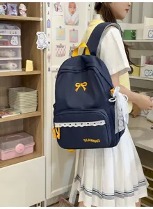 Gedetailleerd zij-aanzicht van de marineblauwe Japanse studentenrugzak met strik.