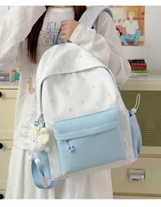 Leuke blauw-witte gestreepte schoolrugzak met sterren en pluche hanger voor dagelijks gebruik.