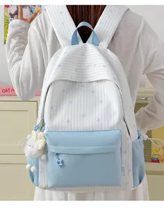 Chique blauw-witte schoolrugzak met sterrenpatroon en pluche hanger voor dagelijks gebruik.