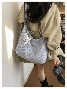 Gedetailleerd overzicht van casual ruitjes schoudertas met schattige sterrenhang en borduurwerk.