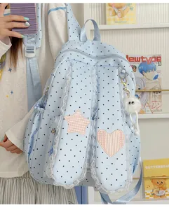 Detail view of sweet polka dot backpack showing lace trim, star patch and cute rabbit ear flaps.