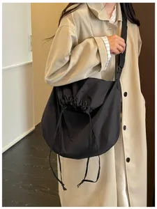Vue détaillée du sac bandoulière noir à cordon avec une grande capacité et un style décontracté.