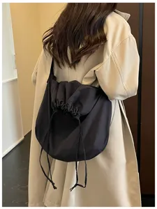 Détail du grand sac à bandoulière noir souple avec cordon de serrage, style tendance.