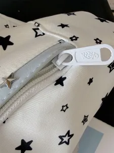 Gros plan sur les détails de la fermeture éclair et de l'étoile en métal du sac.