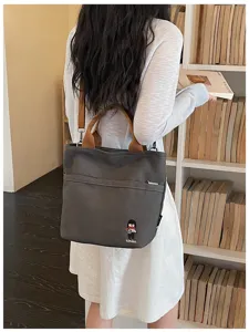 Détail de sac bandoulière en toile, cabas quotidien décontracté avec poignées confortables.