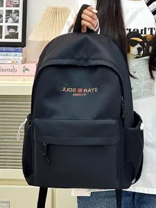 Schwarzer Canvas-Schulrucksack Detail mit Fronttasche und gesticktem Logo Design.