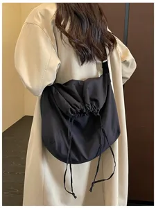 Vue détaillée d'un sac bandoulière noir à cordon mettant en valeur son design souple.