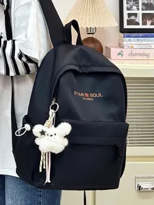 Lockerer schwarzer Schulrucksack mit süßem flauschigen Kaninchenanhänger für den Alltag.