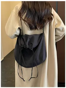 Vue détaillée du sac bandoulière noir à cordon, grand sac porté épaule souple pour tous les jours.