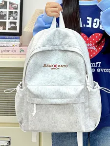 Lässiger grauer Stoff-Schulrucksack im Detail, mit Fronttasche und praktischen Seitenfächern.