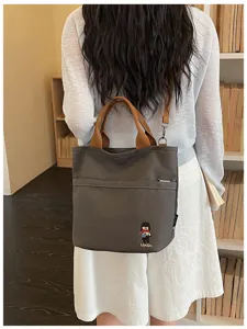 Vue de detail du sac a bandouliere en toile avec poignes marron pour le quotidien.