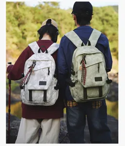 Vue détaillée d'un couple portant des sacs à dos élégants à motif marbre lors d'une randonnée.