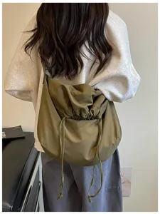 Vue détaillée du sac bandoulière vert à cordon, grande capacité, style besace.
