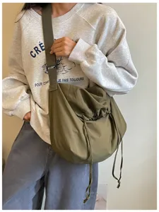 Détail de sac bandoulière cordon grande capacité, sac messager hobo uni pour usage quotidien.