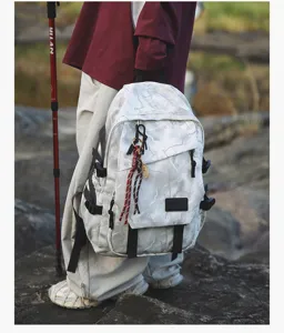 Vue extérieure détaillée du grand sac à dos d'école camouflage gris avec pendentif.