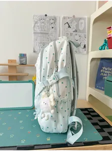 Vue détaillée du sac à dos bleu clair motif étoiles cœurs avec joli pendentif en peluche.