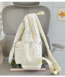 Side detail view of a sweet white polka dot backpack with cute lace ruffles and side pockets.